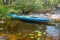 Blue kayak by rocky shore of Unitskaya Bay of Lake Onega, Republic of Karelia, Russia