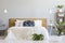 Blue knot pillow on bed with wooden headboard in grey bedroom in