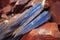 blue kyanite blades on a rust coloured rock