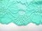 Blue lace fabric on white background from above