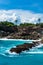 Blue lagoon with palms growing on the cliff