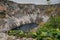 Blue lake, a large sinkhole close to more known Red lake at the edge of village of Imotski in southern Croatia on a gray day