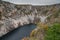 Blue lake, a large sinkhole close to more known Red lake at the edge of village of Imotski in southern Croatia on a gray day