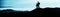 Blue landscape background banner panorama - Breathtaking view with black silhouette of mountains, hills, forest. and two hikers