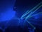 Blue laser light criss crossing a dark room over a crowd.