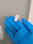 A blue latex glove reaching for a squirt of hand sanitizer during the coronavirus pandemic