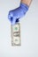 Blue latex gloved hand holding dollar bill. Concept financial crisis coronavirus, covid-19