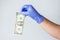 Blue latex gloved hand holding dollar bill. Concept financial crisis coronavirus, covid-19