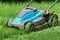 Blue lawnmower cutting grass - closeup