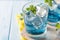 Blue lemonade in glasses on wood background