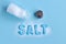 Blue letters spelling the word salt and salt shaker