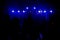 Blue light shine over dancing people in the darkness