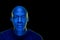 Blue light studio photo of a black man looking at the camera with amazement expression.