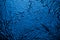 Blue-lighted black wall of texture background light