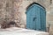 Blue locked gate in old stone wall, Arabic style