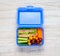 Blue Lunch Box with Vegetables and Sandwich