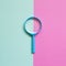 Blue magnifying glass on green and pink background