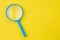 Blue magnifying glass, magnifier on yellow background with copy space using as search, transparent, science discovery or SEO