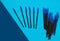 Blue makeup brushes, combs for eyelashes and eyebrows on a blue background