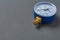 Blue manometer for accurate measurement air or gas pressure lies on dark concrete desk in workshop