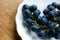 Blue matte grapes on a white porcelain plate