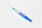 Blue medical disposable syringe for injection on a white background. Medical instrument for vaccination. 10 ml syringe for COVID