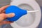 Blue medical enema on the background of a white toilet