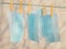 Blue medical face masks hanging on a clothesline with yellow clothespins