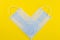 Blue medical masks as a checkmark on a yellow background