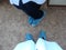 Blue medical shoe covers are worn over shoes on the floor in hospital, black leather mens shoes in overshoes, hygiene and