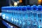 Blue medicine jars on a conveyor belt. Automated pharmaceutical industry