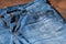 Blue mens jeans denim pants on wooden background. Fashion clothing concept