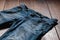 Blue mens jeans denim pants on wooden background. Fashion clothing concept