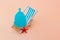 Blue Menstrual cup with a blue deck chair on a peach pastel background. The concept of simplicity and comfort of using the