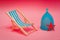 Blue Menstrual cup with a blue deck chair on a pink background. The concept of simplicity and comfort of using the menstrual cup