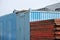 Blue metal containers and red formwork elements at construction site