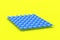 Blue metal roof tile on yellow background. Contemporary roofing system. Building materials