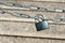 Blue metallic padlock hangs on silver iron chain