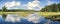 Blue mirror lake reflections of clouds and landscape. Sudbury, Ontario, Canada.