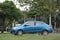 Blue Mitsubishi Attrage sedan, parked outdoors, selectable focus.