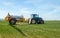 Blue modern tractor pulling a crop sprayer