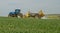 Blue modern tractor pulling a crop sprayer