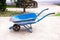 Blue modern wheel barrow isolated in the park