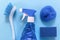 Blue monochrome flay lay of brush, sponges, spray for cleaning