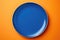 Blue Monochrome Plate On Orange Background, Top View. Generative AI