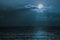 Blue moon light reflecting off ocean. Romantic twilight moonlight