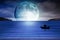 Blue moon rising out of the sea lovers background