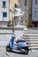 Blue motor scooter parked beside statue in Piran, Slovenia