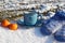 Blue mug with a heart pattern, mittens and two orange tangerines on the snow, side view-the concept of a pleasant winter holiday