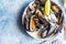 Blue mussels in a creamy white wine sauce served with lime and bread. Stew mussels in wine, leek and blue cheese. Seafood.